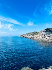 Blue calm ocean bay horizon, small rocky islands, blue sky