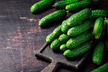Fresh cucumbers on a wooden cutting board. 