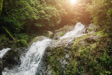 Caucasian turbulent river with a fast current in a stone channel - a view of a mountain forest and a valley - river rapids and waterfalls