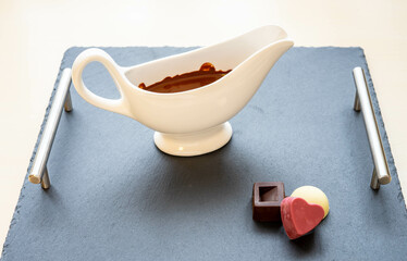 Hot chocolate in a white ceramic bowl and home made pralines