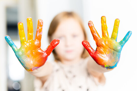 The Little Girl Is Showing Her Painted Hands In Rainbow Colors.