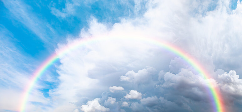 Beautiful cloudy landscape with amazing rounded rainbow in the rain clouds