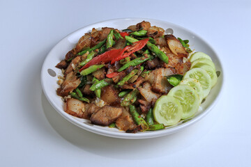 Stir Fried Pork Curry with Long Beans Served with cucumber as a side dish and steamed rice, ready to eat.