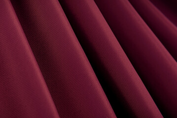 Fototapeta na wymiar Abstract background of satin fabric or silk maroon, red with waves. View from above. The texture is purple. Valentine's Day