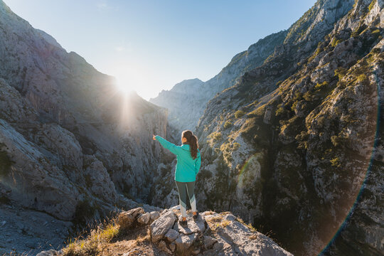 Unrecognizable woman pointing at mountain