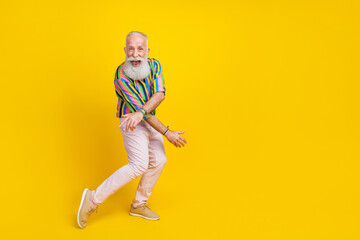 Fototapeta na wymiar Full length photo of charming pretty guy dressed striped shirt having disco fun empty space isolated yellow color background