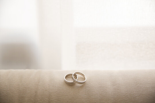 Wedding rings on beige surface