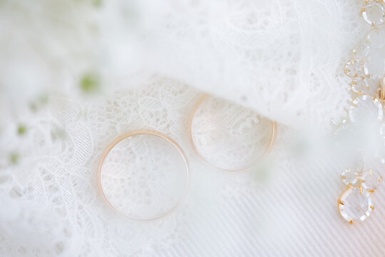 Golden wedding rings on lace fabric