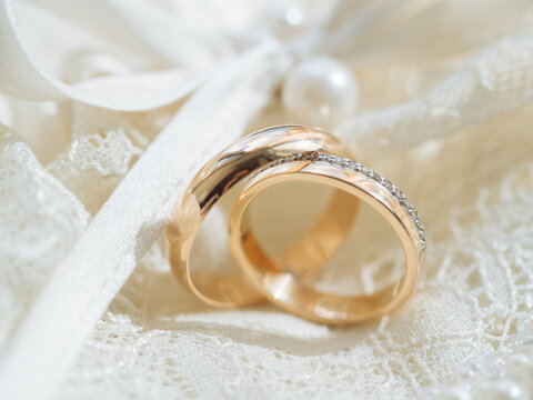 Golden wedding rings on lace fabric