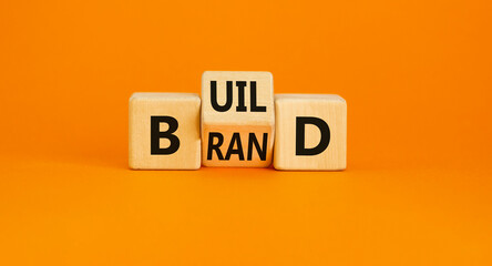 Build your brand symbol. Concept word Build brand on wooden cubes. Beautiful orange table orange...