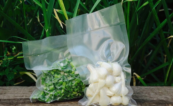 Foodsaved product. Green food in a plastic film package, removed air from inside and sealing the package