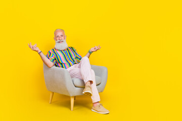 Full body photo of funky cheerful granddad sit armchair communicate say tell isolated on yellow...