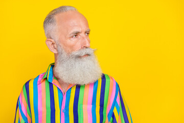 Photo of focused concentrated aged person strict face look interested empty space isolated on yellow color background