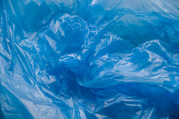 Texture and background of a blue plastic bag. Blue disposable plastic bag. Environmental problems, recycling, waste.