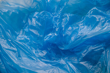 Texture and background of a blue plastic bag. Blue disposable plastic bag. Environmental problems, recycling, waste.