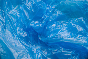 Texture and background of a blue plastic bag. Blue disposable plastic bag. Environmental problems,...