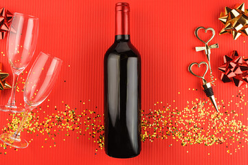 Still life with a bottle of wine, a corkscrew and a cork with heart-shaped handle on red background. View from above. - 564313991