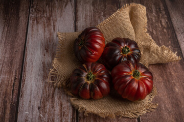 Fototapeta na wymiar group of moorish tomatoes on a raffia cloth on a wooden table