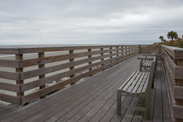 Obraz premium empty benches on an ocean side boardwalk