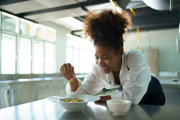 Fototapeta na wymiar Happy African - black professional chef cooking in kitchen in restaurant.