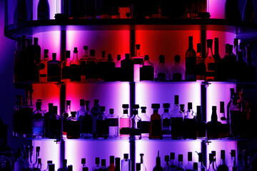 A lot of alcohol bottles in a modern bar. Pub background with drink silhouettes.