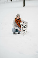 Frau posiert mit Hund im Schnee während Winter