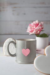 A cup, gingerbread in the form of hearts and a white-pink rose. Romance and Valentine's Day