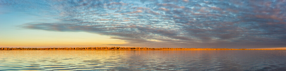 Obraz premium Colorful sunset clouds over wide Volga river reflecting in water