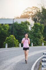 Beautiful Healthy woman running jogging  in the park in the morning. She smiled and enjoyed.  Healthy active lifestyle concept.