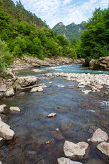 Summer, river, mountainous terrain, tourist routes running through the park, a place for walking and recreation.