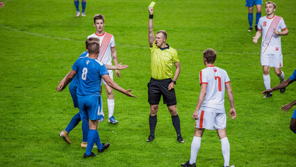 Soccer Football Championship Match: Referee Sees Foul, Gives Signal and Yellow Card, Players Circle him Upset. International Tournament. Sport Broadcast Channel Television Concept. - obrazy, fototapety, plakaty