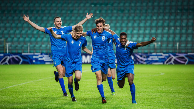 Fototapeta Soccer Football Championship: Blue Team Forward Attacks and Scores Goal, Win the Match, Players Happy, Celebrate Victory, Win Tournament. Sport Channel Broadcast Television Concept.