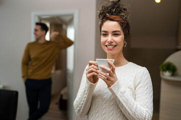 young couple woman with cup of coffee chat with husband at home