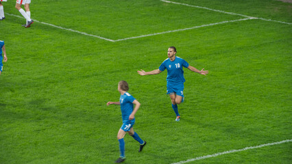 Obraz premium Championship Match: Blue Soccer Football Team Attack, Player Run Happy after Scoring Goal, Celebrate Victory, Cheering with Teammates on Field. Sport Channel Broadcast Television Concept.
