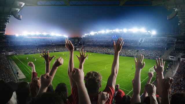Establishing Shot of Fans Cheer for Their Team on a Stadium During Soccer Championship Match. Teams Play, Crowds of Fans Scream and Celebrate Victory, Goal. Football Cup Tournament. Wide Shot