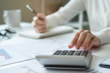 Women business people use calculators to calculate the company budget and income reports on the...