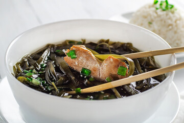 Korean seaweed soup with meat in white bowl and boiled rice. Birthday soup. Traditional Korean Cuisine. Healthy diet. Pregnancy. Custom. Close up. © EKATERYNA