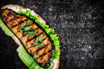 One sandwich with eggplant grilled on the table. 