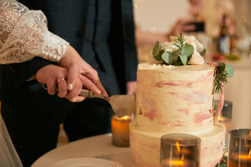 Naklejka na ściany i meble bride and groom cutting wedding cake together