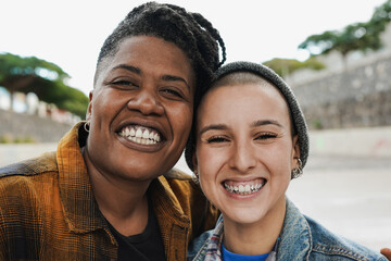 Young multiracial female friends smiling on camera