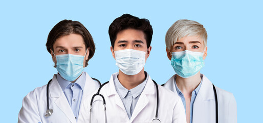 Multiethic team of doctors in medical face masks on blue