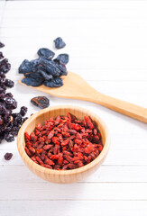 dried goji, cherry, raisin and plum fruits on white wood