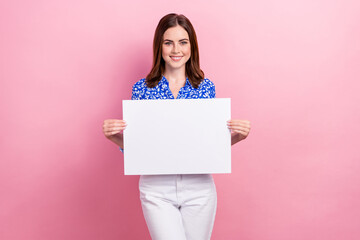 Photo of young cheerful positive smile promoter lady wear stylish smart casual outfit hold paper banner empty space isolated on pink color background