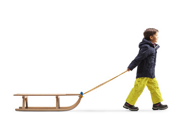 Full length profile shot of a boy pulling a wooden sleigh