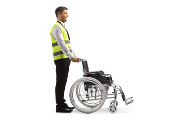 Full length profile shot of a guard standing behind a wheelchair