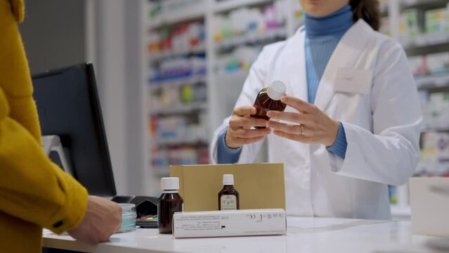 Young pharmacist explaining to customer how to dosing medication.