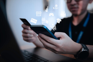 Hand of asian man holding smartphone with credit card,Pay for various bills that use a credit card