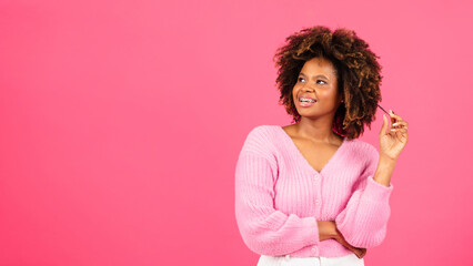 Cheerful surprised millennial african american curly woman with braces in casual looking at copy...