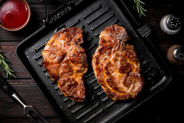 Grilled pork steak in a frying pan. 