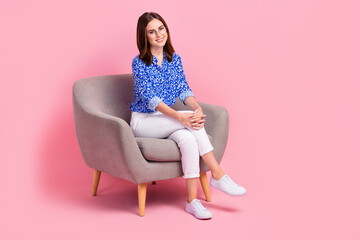 Full length photo of shiny adorable lady wear print shirt sitting sofa empty space isolated pink color background